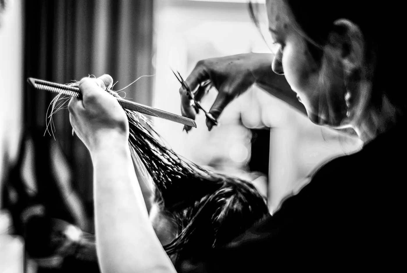 Frizerka šiša mokru kosu, crno-bijela fotografija